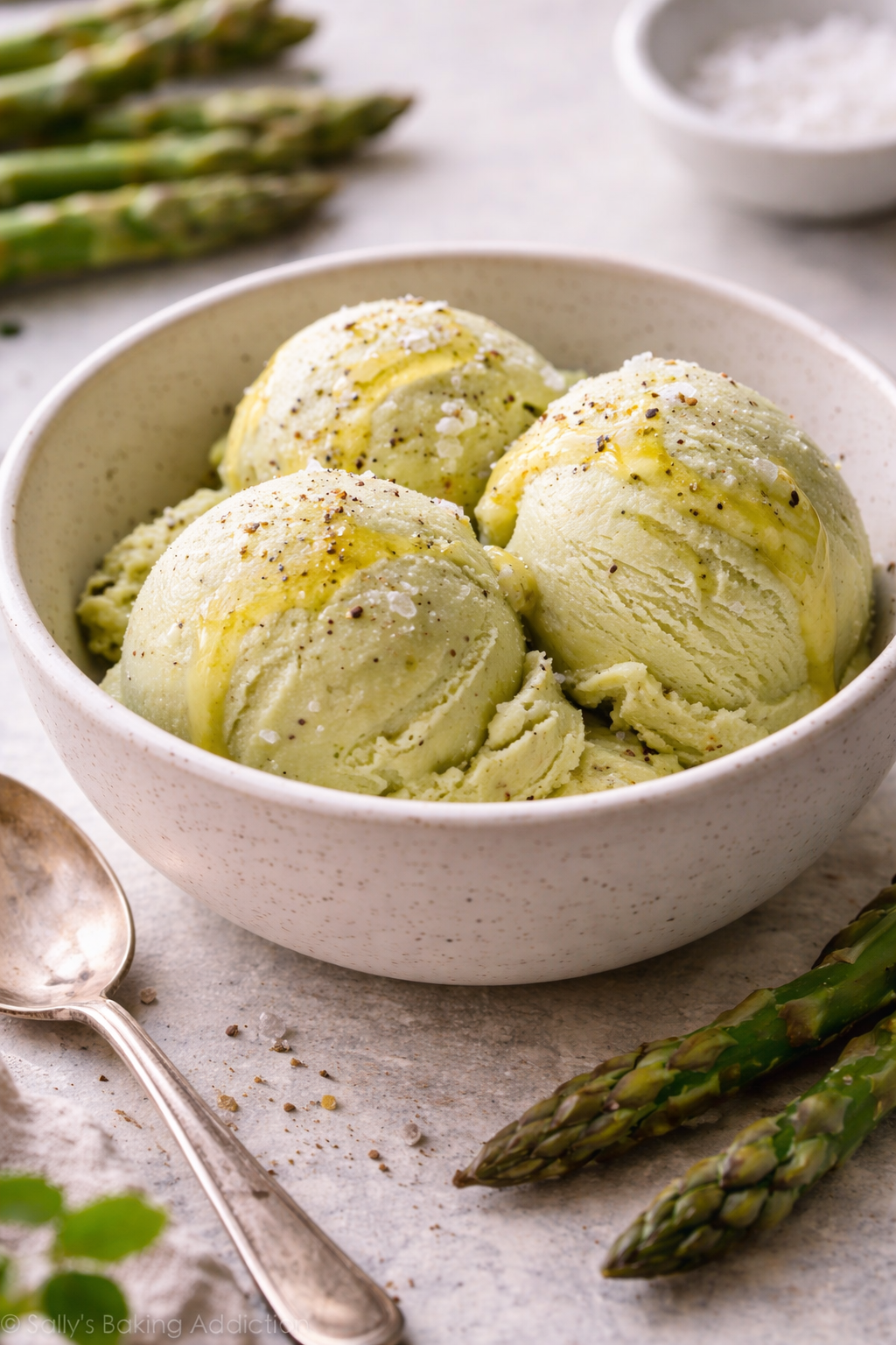 Creamy asparagus ice cream served in a bowl with a smooth, pale green color, photographed in natural light.
