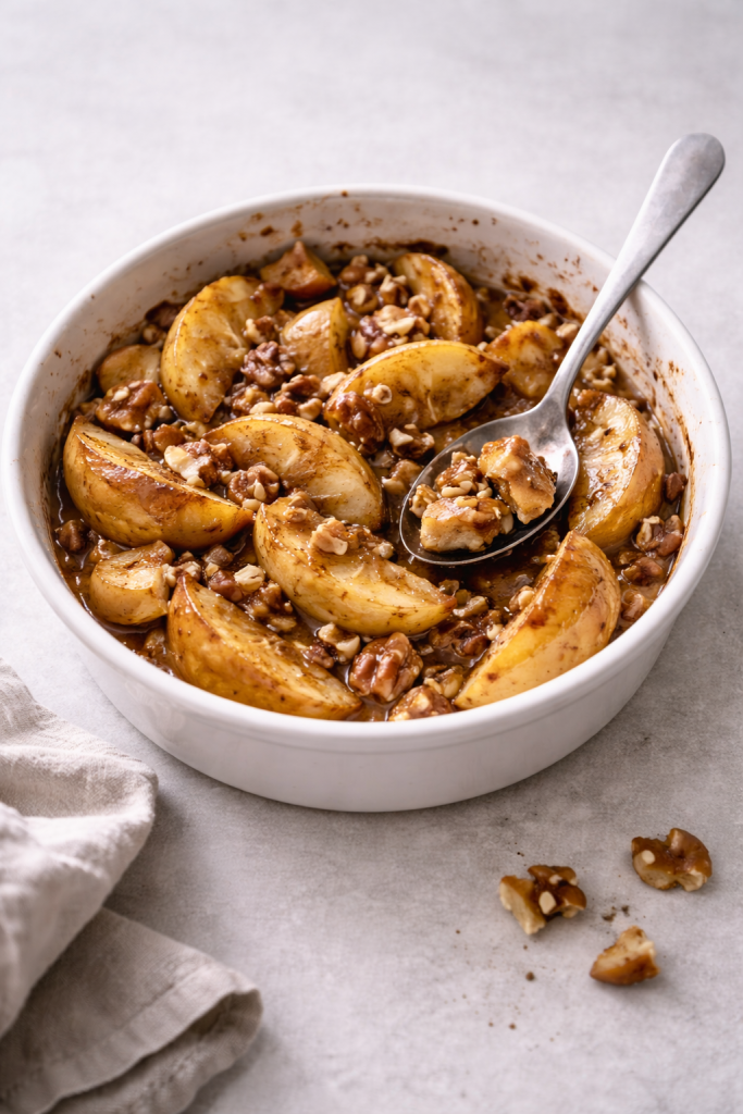 Baked apples with cinnamon and nuts served warm in a rustic baking dish