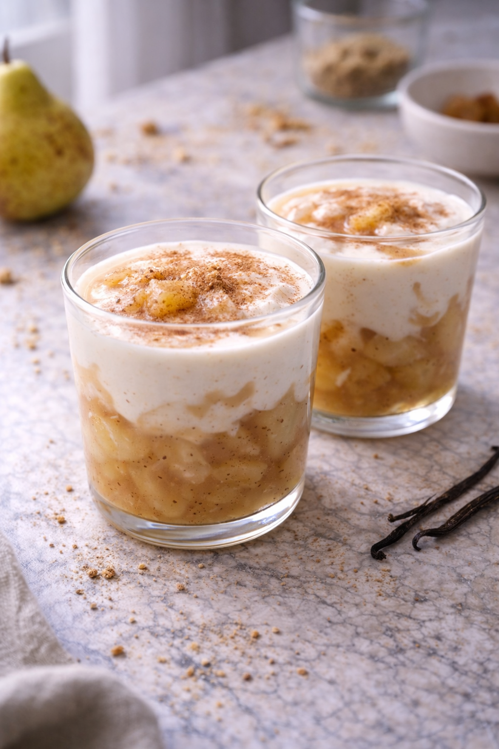 Creamy pear and cinnamon dessert layered with buttermilk cream, served in a glass in natural light.