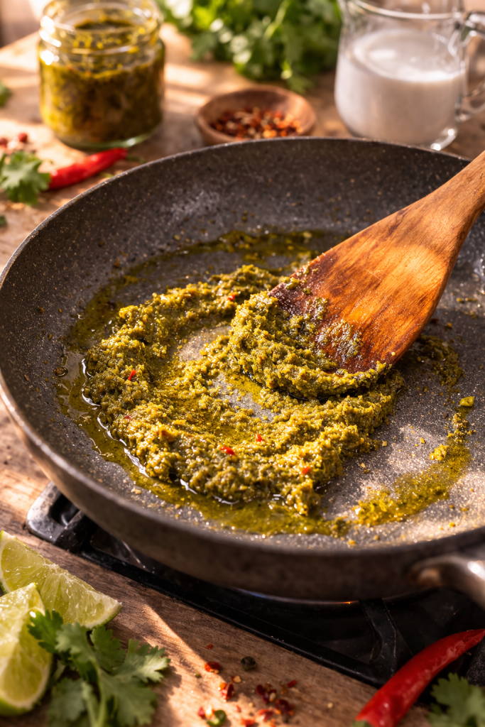 green curry paste frying in a pan with oil while preparing one pot shrimp green curry