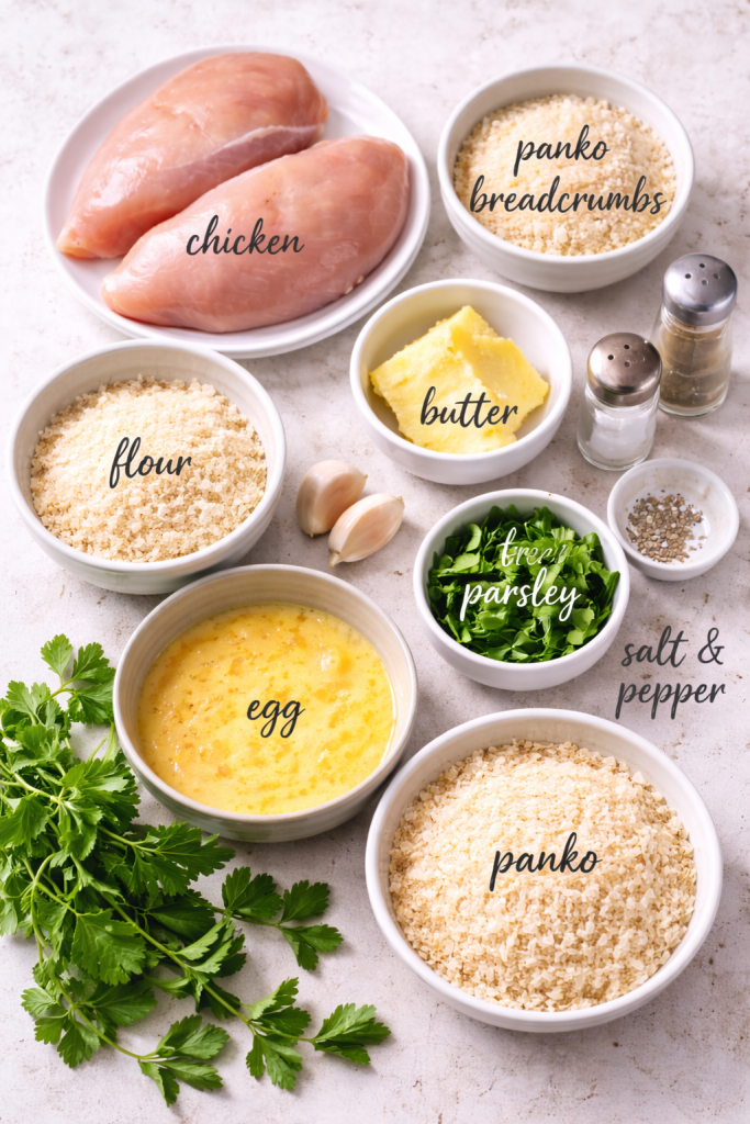 Ingredients for air fryer chicken kiev including chicken breasts, butter, garlic, parsley, egg, flour, and breadcrumbs