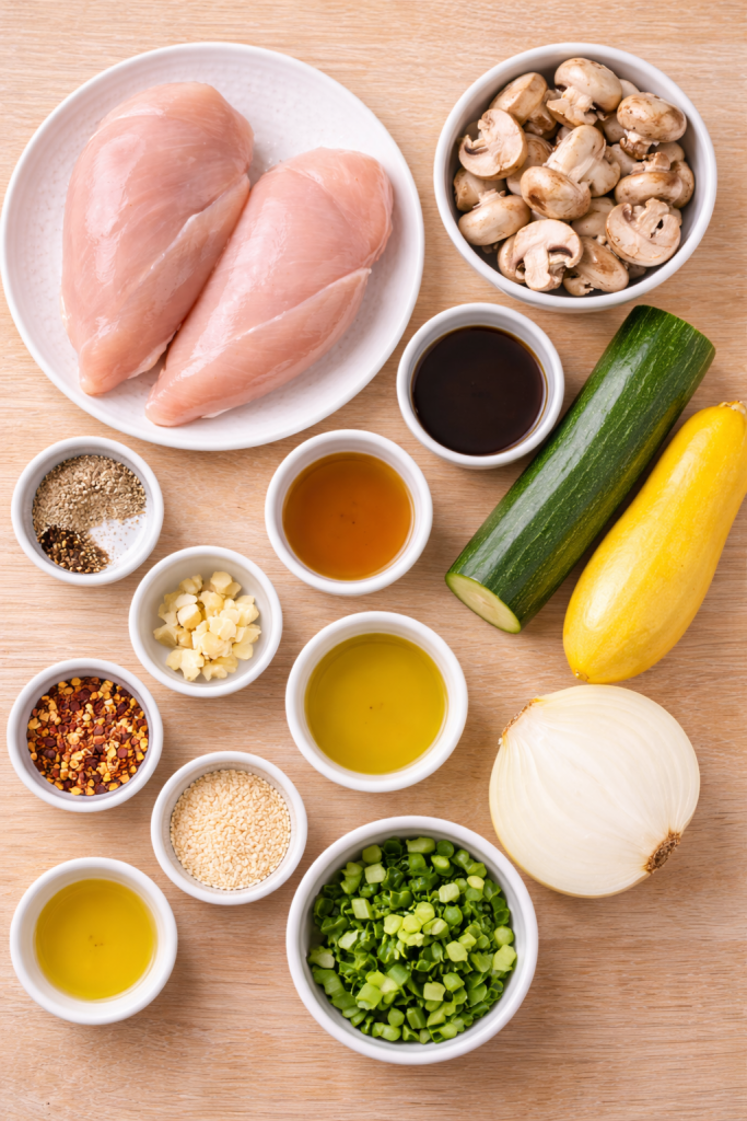 ingredients for air fryer hibachi chicken arranged on light wooden table overhead view
